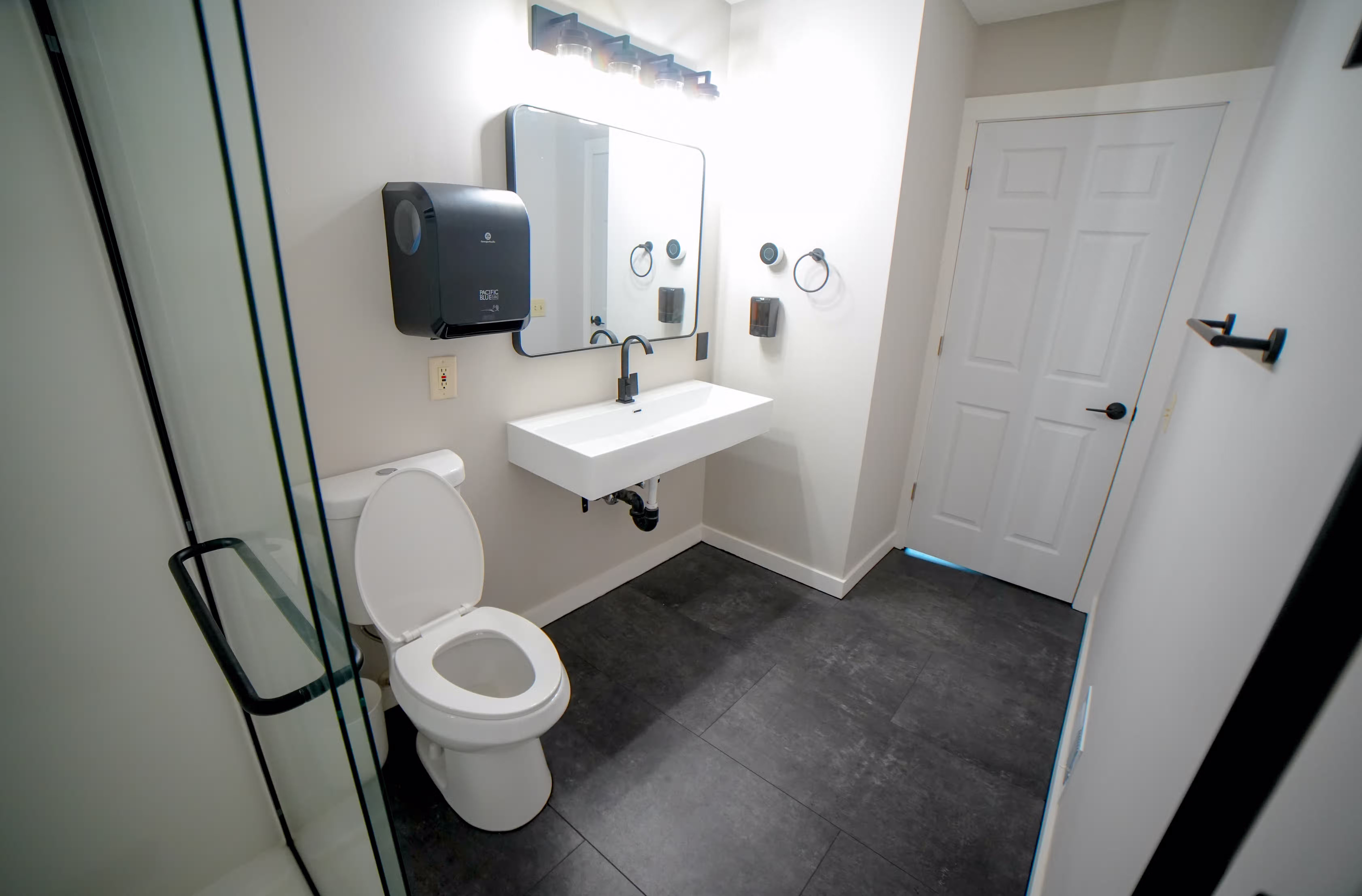 ADA accessible bathroom with grab bars, roll-in shower, and wheelchair-friendly sink for residents in assisted living in Minnesota