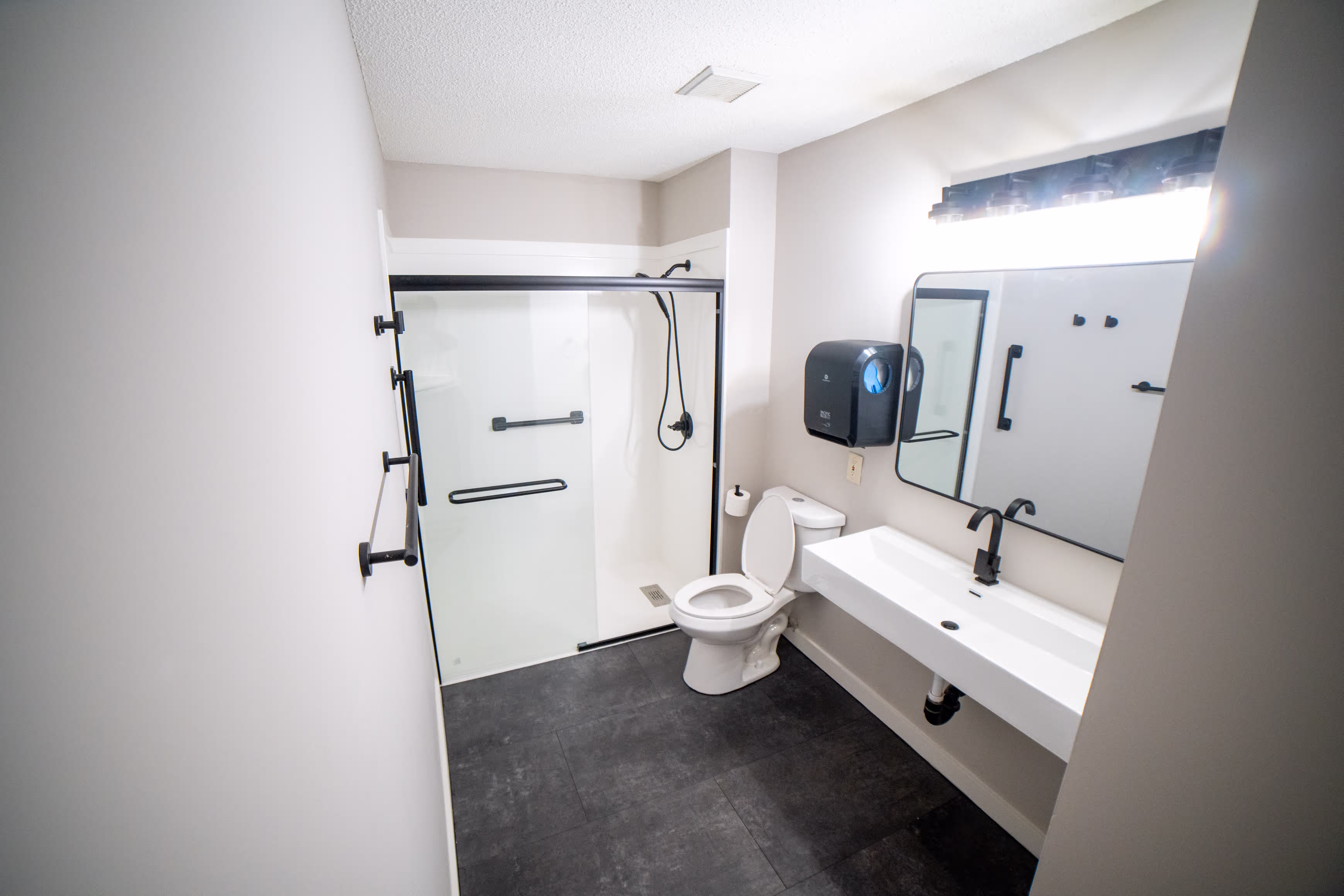 Spacious ADA compliant bathroom with wheelchair access, slip-resistant flooring, and supportive grab bars for residents in assisted living in Minnesota